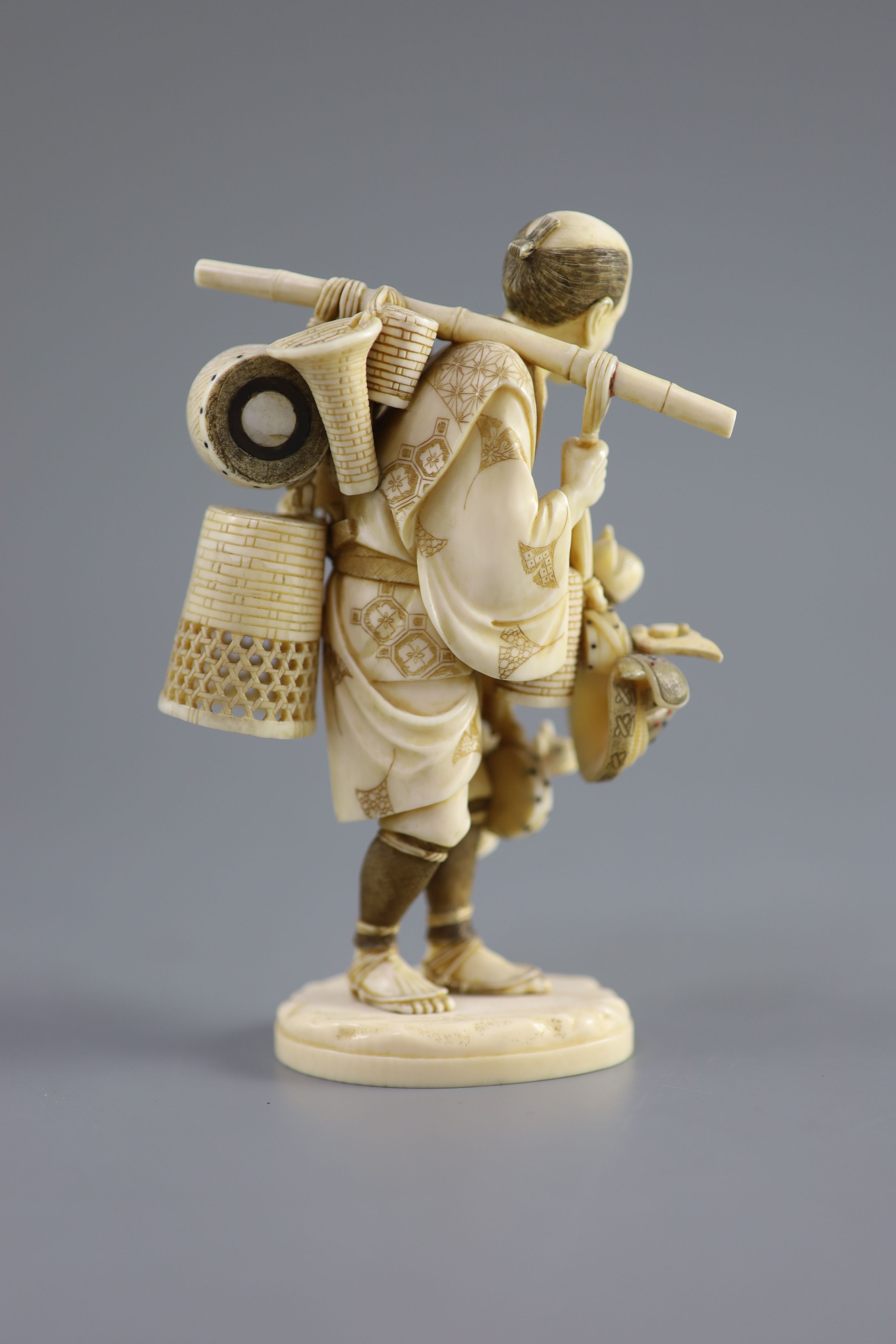 A Japanese ivory okimono of a basket seller, early 20th century 14.5 cm high